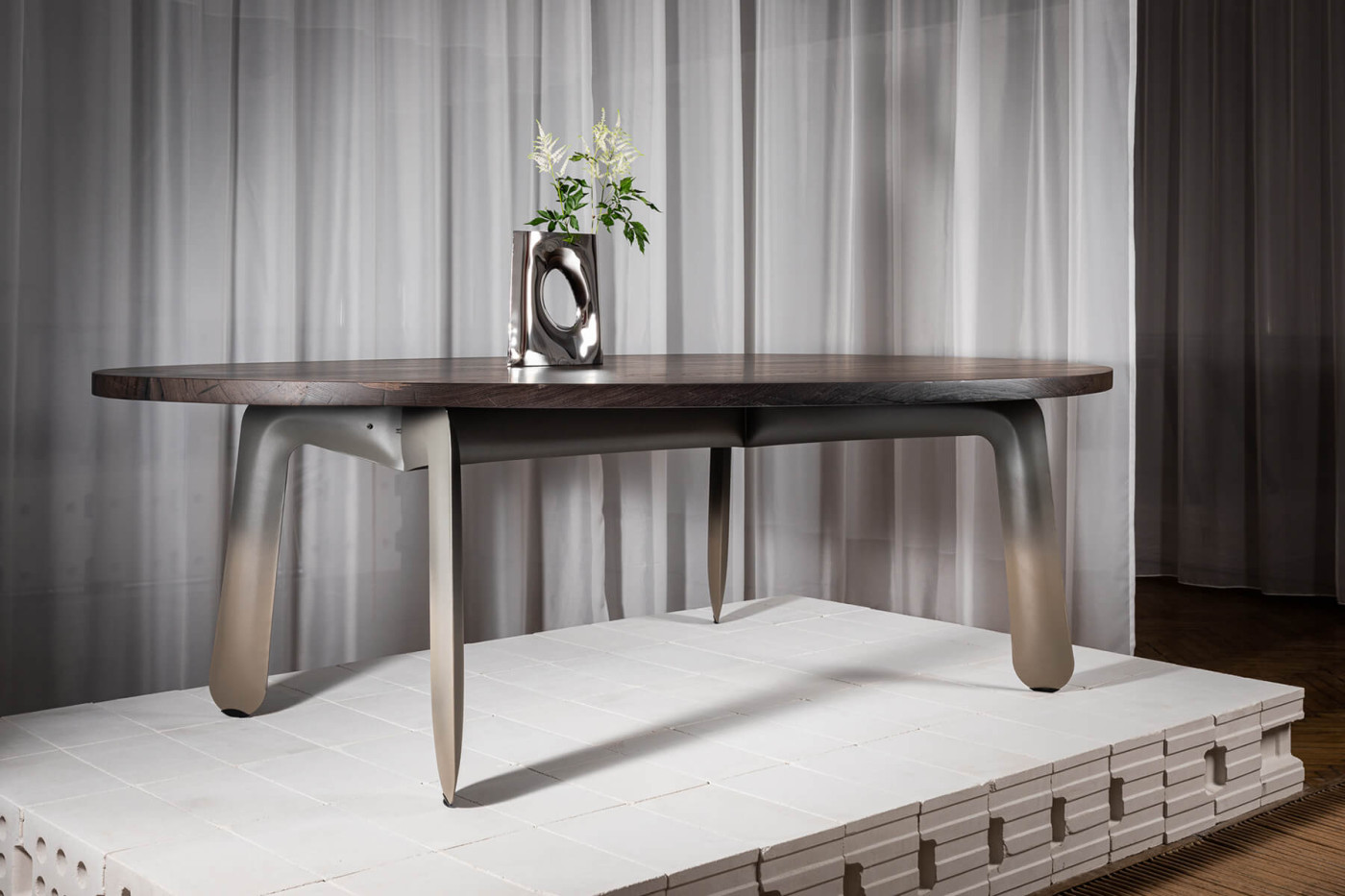 blown metal vase on metal table