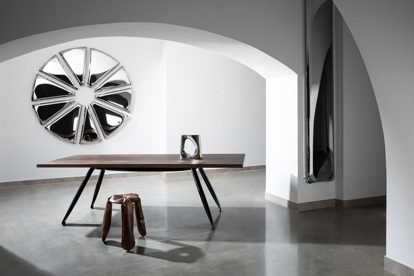 a steel base of table , sculpture and stool in minimalistic interior
